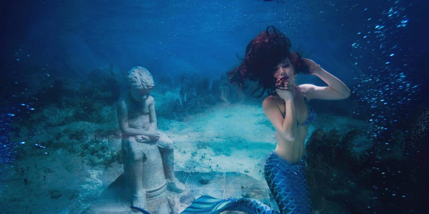 a woman underwater with a mermaid tail